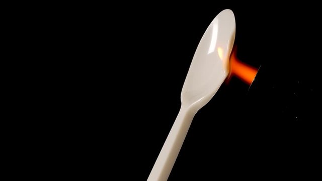 Torch is melting plastic spoon. Concept for plastic ban.