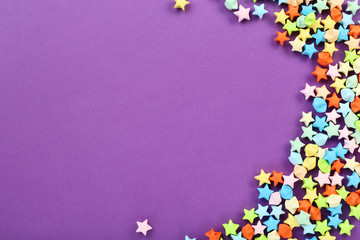 Colorful paper stars on purple background