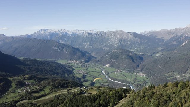 Aerial view of two guys flying in tandem paraglide above Soča Valley in Kobarid