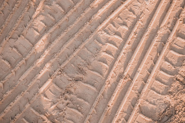 Sand surface/dirt road with wheel marks.