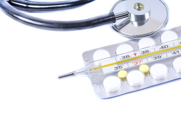 Stethoscope, medicine and thermometer on a white background