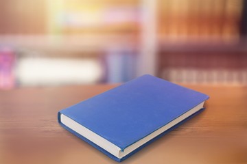 A blue book on a wooden table in the library