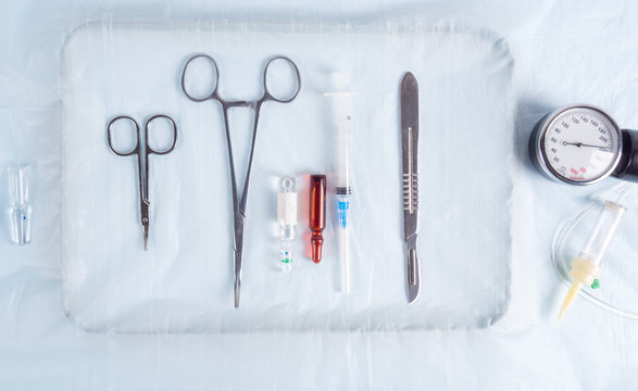 Surgical clamps, scalpel and syringe on the table