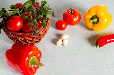 Basket with red tomatoes, peppers, herbs. Ingredients for cooking.