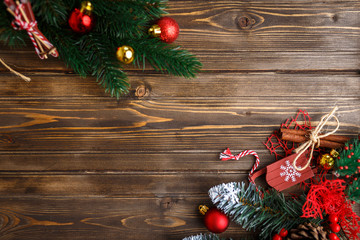 Fototapeta na wymiar Fir branch with Christmas decorations on old wooden brown background with copy space for text