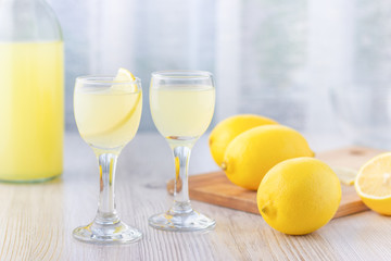 Alcoholic drink liquor lemoncello (limoncello) in a small glass. Italian beverage from fresh lemon.