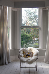Modern armchair covered in soft furnishings in a bright room