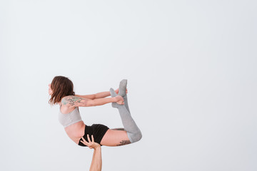 young couple Couple practicing acro yoga in white studio or gym. Healthy lifestyle