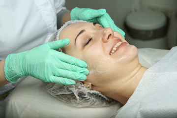 doctor's hands in gloves make facial skin rejuvenation. beautician is washing the patient's face. preparing the face for cosmetic treatments close up.