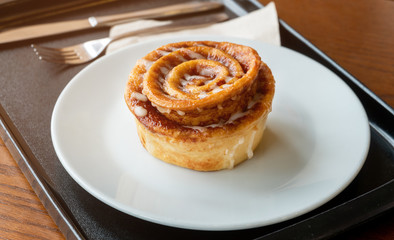 Cinnamon Bread Placed on a white plate in a food tray placed on the table Complete with knives and spoons, tissue paper beside