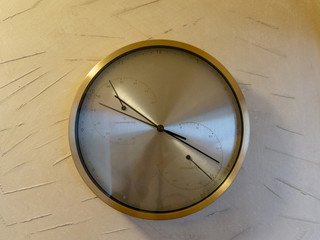 Round metal clock on white wall