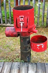 Fototapeta na wymiar A red pump used for water
