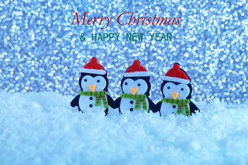 Merry Christmas and happy New Year greeting card with copy-space. penguins standing in winter Christmas landscape. Winter background