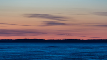 Fototapeta premium Frozen lake at sunset time in late winter in Finland