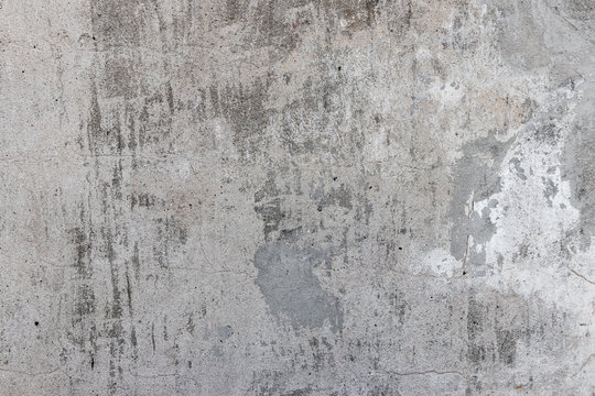 Texture of old gray concrete wall with spots, smudges, traces of paint, scratches, roughness for background
