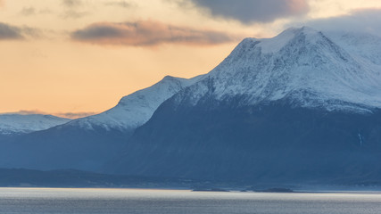 Fototapeta na wymiar Mountains by a fjord with some snow