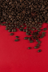 Coffee beans are scattered on a red paper background close-up, commercial copy space.