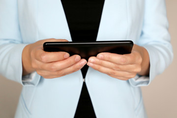 Woman in business suit watching video on smartphone display. Concept of social media, online, adult movies, office leisure