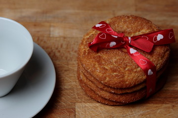 cookies with a red bow of white hearts and next to it should half a cup on your plate