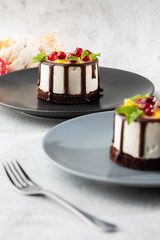 Mini round souffle cake with fruit and chocholate glaze on topc on marble background. Wallpaper for pastry cafe or cafe menu. vertical.