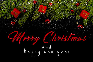 Christmas composition. Girlanda with red Christmas ornaments, gifts and snow on black background. Christmas, winter, new year concept. Flat lay, top view, copy space. © Julio Ricco