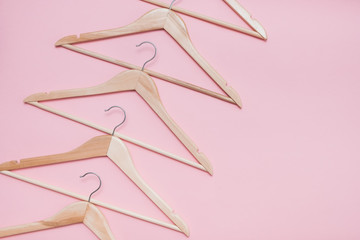 wooden empty clothes hangers on a pink background. concept: pop modern sale