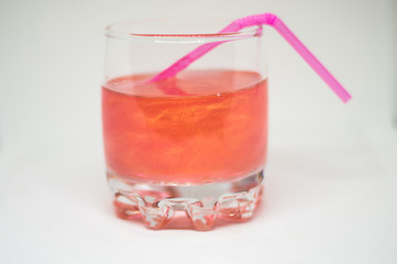 Pink drink in a glass cup with a pink straw for cocktails isolated on white background