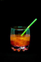 Glitter drink with a cocktail tube close-up isolated on a black background