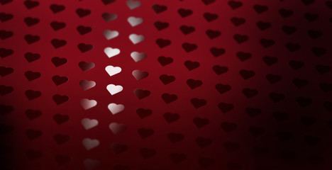 A heart pattern of spot uv varnish print on red note paper background.