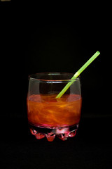 Glitter drink with a cocktail tube close-up isolated on a black background