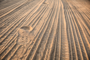 Fototapeta na wymiar tire tracks on the sand. background of tyre tracks and footprints