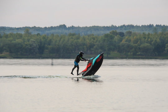 man in a helmet and wetsuit performs tricks on a jet ski. sport riding a personal watercraft. stunt riding on jet ski