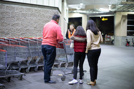 People with carts in Costco Wholesale. Costco is an American multinational corporation which operates a chain of membership only