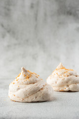 French meringue cookies, macro shot on bright marble background. Tray of meringues. Closeup meringue photo. Dessert background. Sweets. Food. Flat lay and copy space. Top view. Vertical
