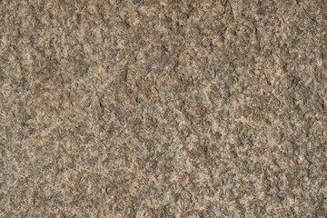 The texture of the brown stone is natural. Background made of stone, covering a wall or floor. Old weathered stone with.