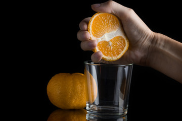 squeezes an orange into a glass