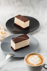 Piece of cake with souffle Bird's milk , biscuit, mousse and dark chocolate on a dark plate, white souffle cake. Menu for bakery. cafe menu. Delicious and sweet dessert at cafe restaurant.Vertical