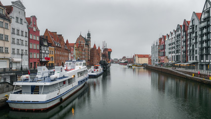 Fototapeta premium City Gdansk in Poland with the oldest medival port crane called Zuraw and a promenade along the riverbank of Motlawa River. November.