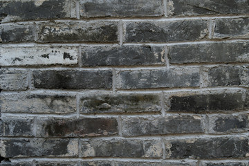 Dirty old curved brick wall. Background of white and black brick after a fire, scratched and old wall.