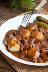 Stew served with silesian noodles and sauce.