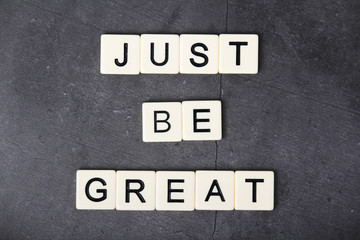 A motivational quote Just be great formed with tile letters	