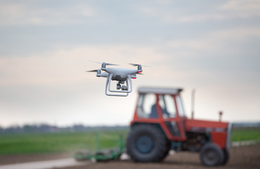 Drone in front of tractor in field