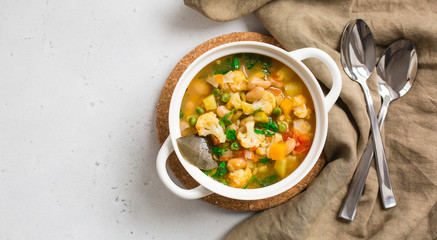 Homemade Italian minestrone - rustic vegetarian soup made with: beans, cauliflowers, onion, celery, carrots, tomatoes, potatoes, zucchini.