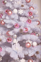 Fototapeta na wymiar White Christmas tree with holiday decorations. New year background