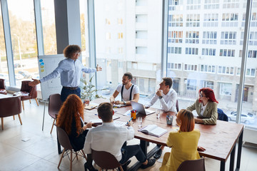 Working, discussion process in business center. Young leaders in formal wear gathered in conference office with panoramic view on city