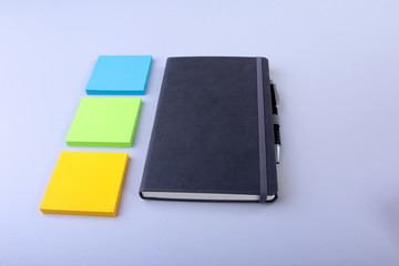 Fototapeta premium Top view of blank notebook and empty note sticker on a blue background. Back to school concept. Flat lay