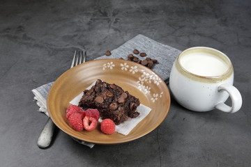 Homemade Chewvy Brownie with Raspberries and a cup of milk