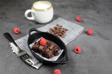 Homemade Chewvy Brownie with Raspberries and a cup of milk