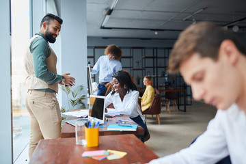 Fototapeta premium Enthusiastic and ambitious team of business people together sit on table and discuss future steps for business strategy. office background