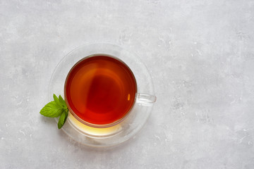 Top view of glass cup with tea on light background